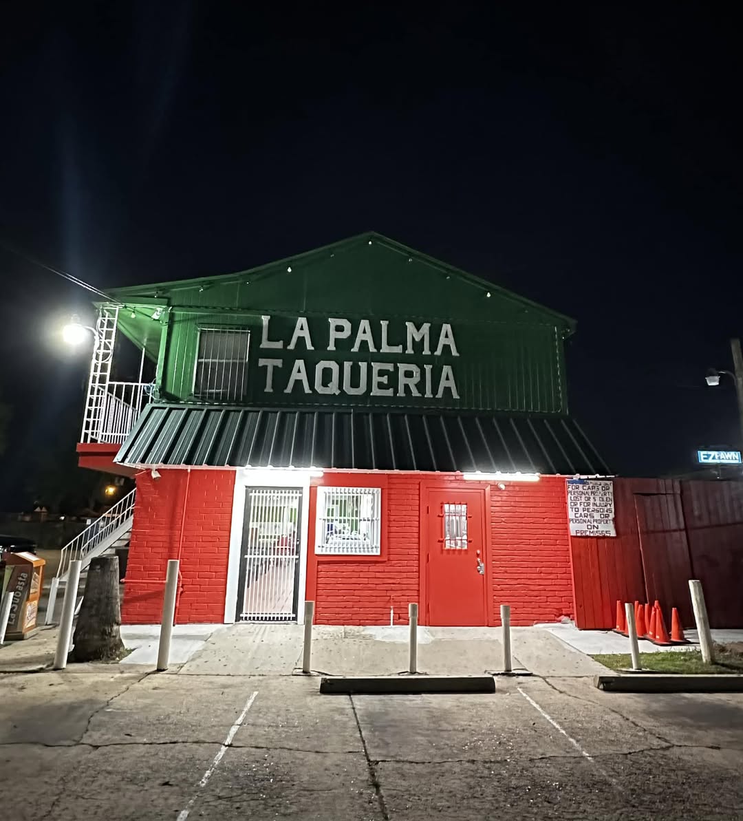 La Palma Taqueria storefront lit up at night in Conroe, Texas